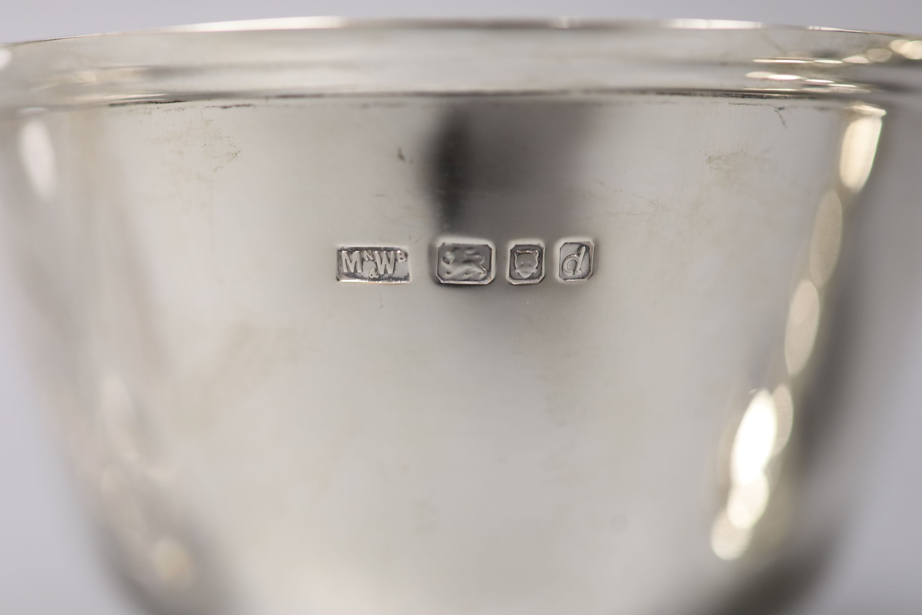 A small circular silver footed bowl, a two-handled silver trophy cup and a cut glass bottle